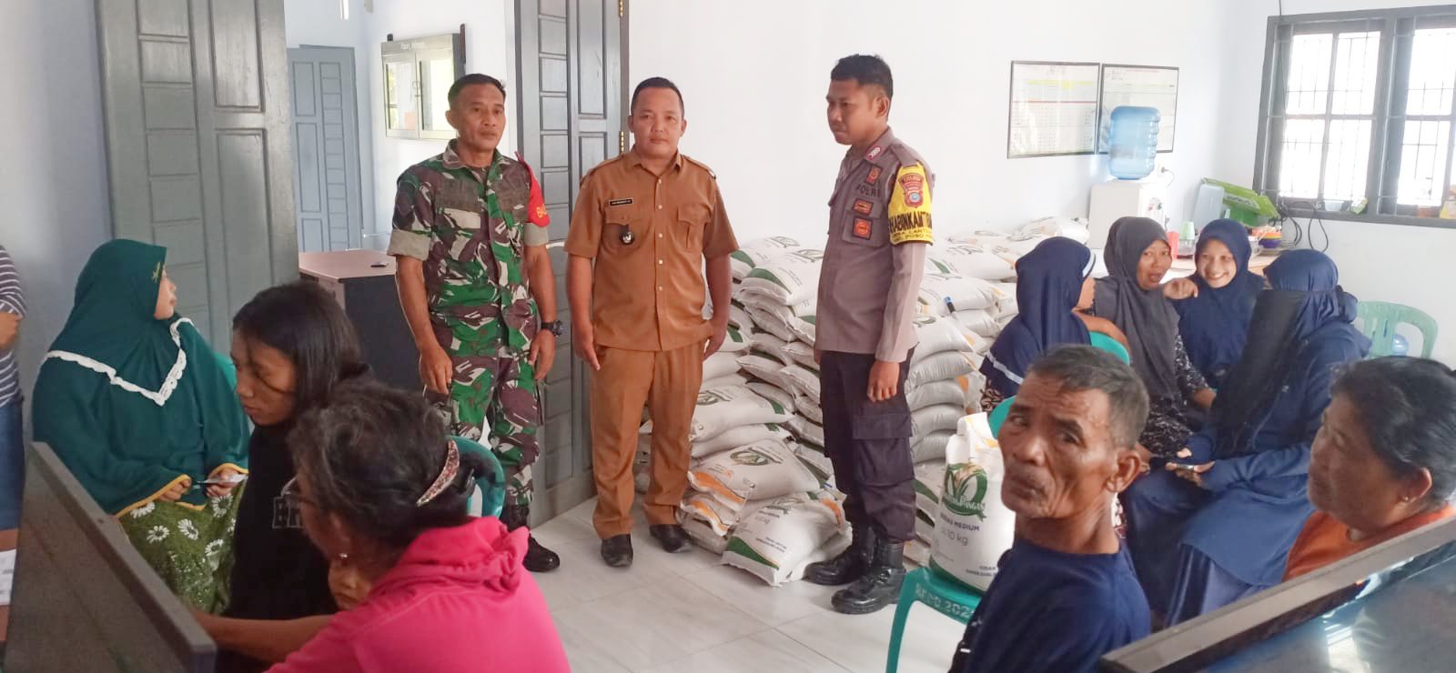 Bhabinkamtibmas Desa Lantojaya Ada Ditengah Warga Saat Penyaluran Beras Bantuan Pangan
